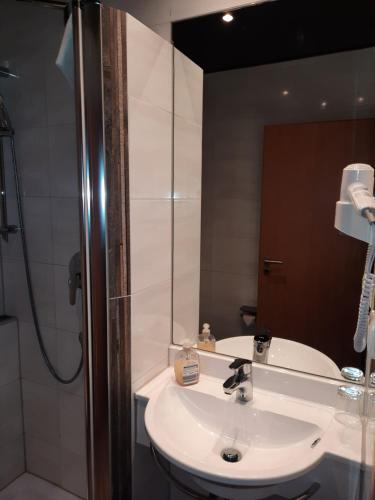 Esselbach塔布里克酒店的浴室配有白色水槽和淋浴。