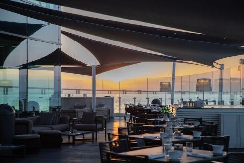 里斯本米瑞亚德SANA酒店的一间带桌椅并享有水景的餐厅