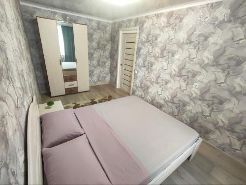 库斯塔奈2-х комнатная квартира в центре на ул.Бородина 107的一间小卧室,配有一张床和镜子