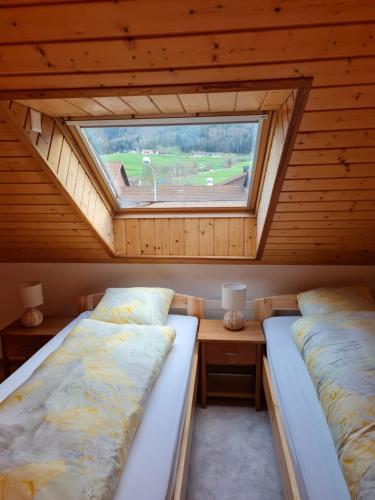 韦尔申罗尔Dachwohnung in Welschenrohr的带窗户的客房内的两张床