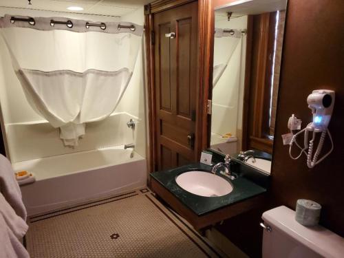 戴德伍德历史布洛克酒店的一间带水槽、浴缸和卫生间的浴室