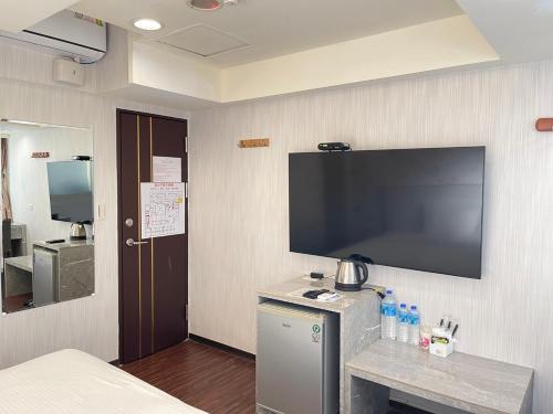 中坜中興商旅  的酒店客房的墙上设有大屏幕平面电视。
