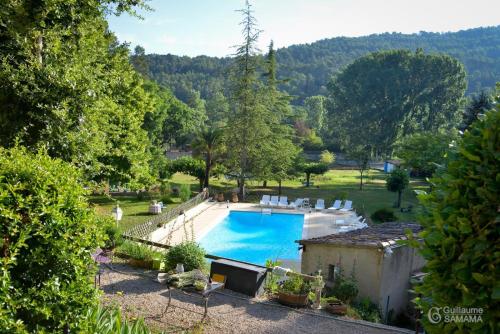 萨雷尔讷普罗旺斯安内区度假屋的庭院内的游泳池,带椅子和树木