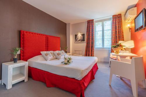 莱塞齐耶德泰阿克Hostellerie du Passeur - Hôtel & Restaurant - Climatisation et Piscine chauffée的一间卧室配有一张大床和红色床头板
