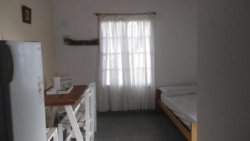 GualeguaychúBoa Vida的客房设有床、书桌和窗户。