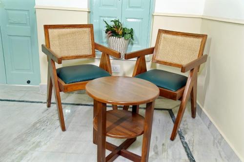 范兰德凡Shree Krishna Bhakti Ashram的房间里的两张椅子和一张桌子