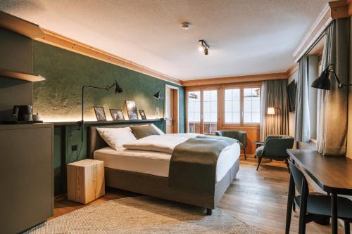 格林德尔瓦尔德Hotel Fiescherblick的配有一张床、一张桌子和一张桌子的酒店客房