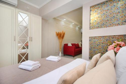 阿拉木图Уютная студия на Арбате的卧室配有白色的床和红色沙发