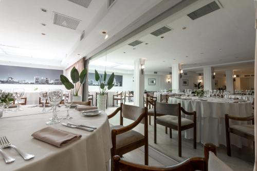 布宜诺斯艾利斯Feir's Park Hotel & Rooftop的一间设有白色桌椅的用餐室