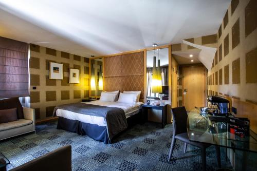 伯尼索米诺格Hôtel Baud - Teritoria的酒店客房设有一张床铺和一张玻璃桌