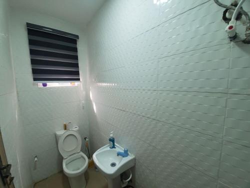 拉各斯Dinero Ruby - Studio Apartment的白色的浴室设有卫生间和水槽。
