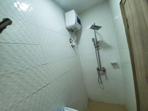 拉各斯Dinero Ruby - Studio Apartment的带淋浴的浴室,墙上配有电话