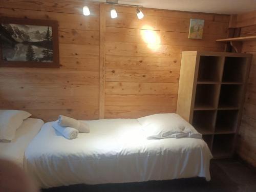 夏蒙尼-勃朗峰Three Bedroomed Chalet Apartment的卧室配有木墙内的两张床