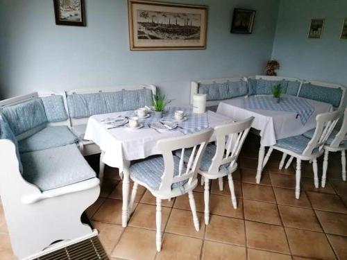 瓦尔斯罗德Pension Weidengrund的一间配备有白色桌椅的用餐室