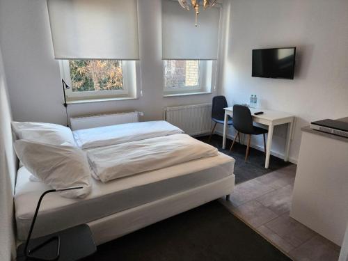 汉堡Davin City Aparments - Self-Check-In的一间卧室配有一张床、一张书桌和一台电视