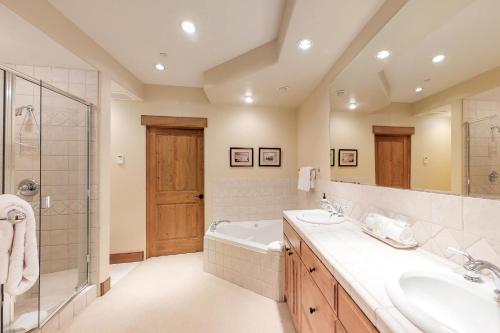 凯彻姆Westridge 11的浴室配有2个盥洗盆、浴缸和淋浴。