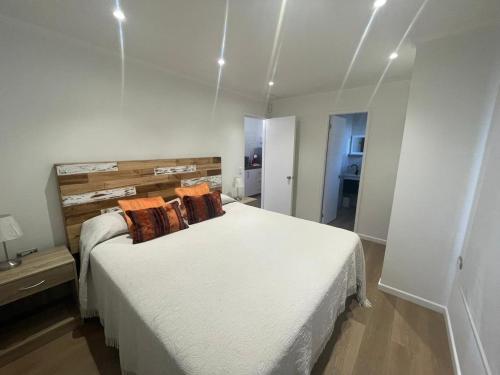 埃尔基斯科Casa nueva de playa 3D 2B的卧室配有带橙色枕头的大型白色床