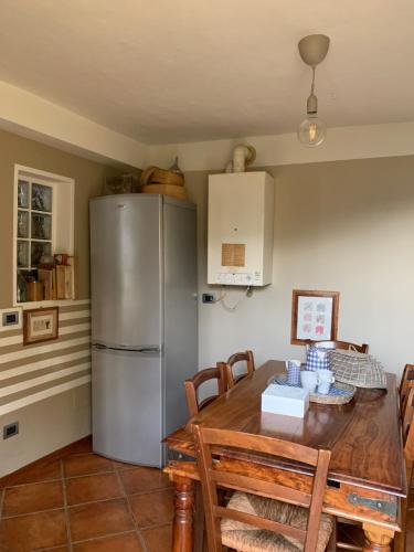 切尔诺比奥Il Riccio appartamento的厨房配有桌子和不锈钢冰箱。