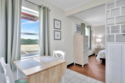 帕诺滩Seahorse Guesthouse的一间带书桌的房间和一间带窗户的卧室