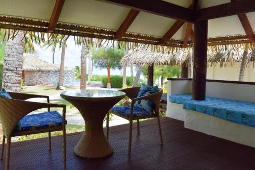 阿鲁坦加琼崖海棠海滩酒店的门廊上配有桌椅的房间