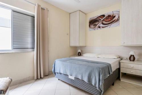 瓜鲁雅Apartamento encantador no Guarujá, praia da Enseada - Apenas 600m da praia !的一间卧室设有一张大床和一个窗户。