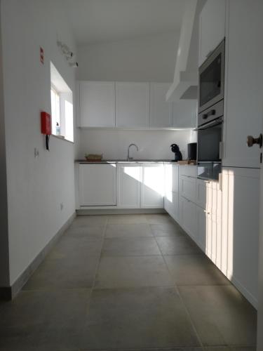 维拉多比斯坡Tasi Ingrina的白色的厨房配有白色橱柜和水槽