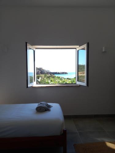 维拉多比斯坡Tasi Ingrina的一间卧室设有一张床和一个开放式窗户。