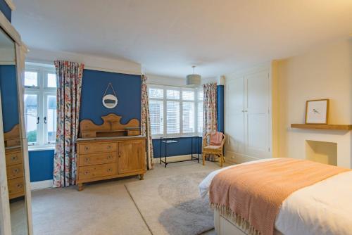 海斯Prospect Cottage by Bloom Stays的一间卧室配有一张床、梳妆台和窗户。