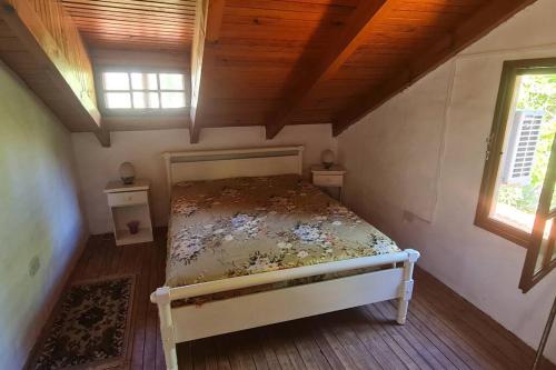 罗卡将军市Casaquinta en la costa del Rio的卧室配有床,位于带2个窗户的房间
