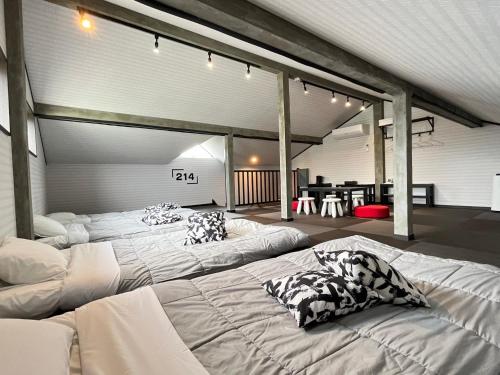 富士河口湖SAMURISE 81INN - Vacation STAY 60983v的一间设有三张床和枕头的客房