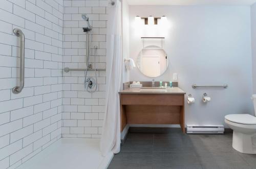 坎卢普斯Prestige Kamloops Hotel的一间带水槽、淋浴和卫生间的浴室