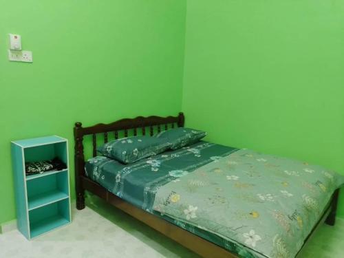 哥打巴鲁PCB PURPLE GUEST HOUSE的一间绿色卧室,配有床和床头柜