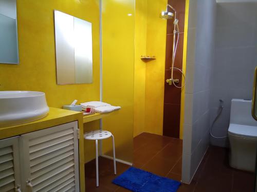 Phumĭ MréchKoh Ker Temples Garden Hotel and Restaurant的黄色的浴室设有水槽和淋浴