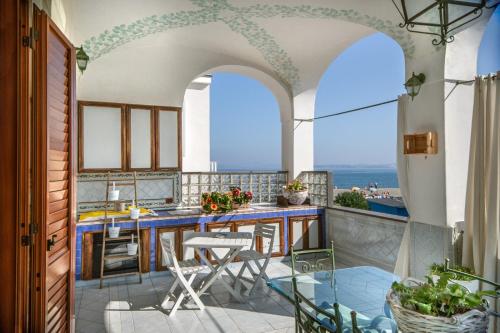 伊斯基亚La Finestra sul Mare的阳台的厨房配有桌椅