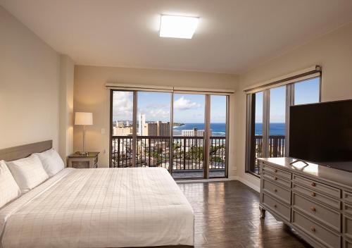 塔穆宁景湾关岛酒店的一间卧室设有一张大床和一个大窗户