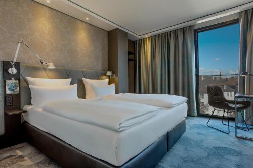 慕尼黑慕尼黑赛德灵格门1号汽车酒店的卧室设有一张白色大床和一扇窗户。