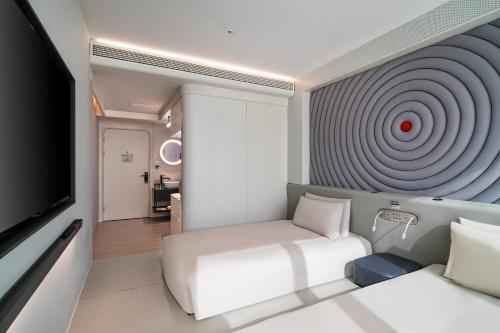 上海静安寺淮海中路亚朵X酒店的一间房间,配有一张床,墙上有目标