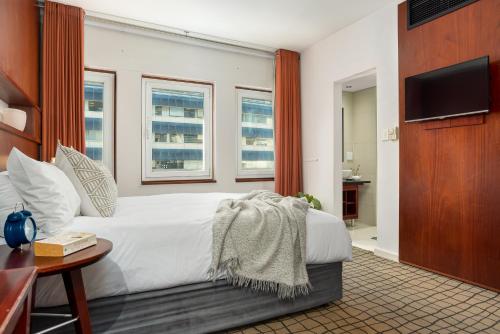 开普敦Neighbourgood East City的卧室配有白色的床和电视。