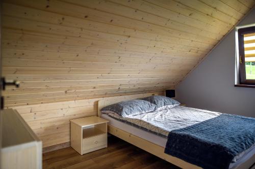 乌伊索维Domek w Klisiówkach的木墙客房的一张床位