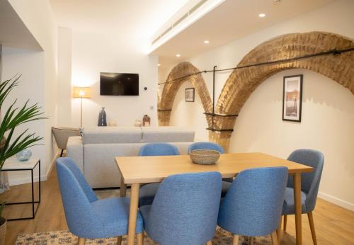 塞维利亚nQn Aparts & Suites Sevilla的一间带桌子和蓝色椅子的用餐室