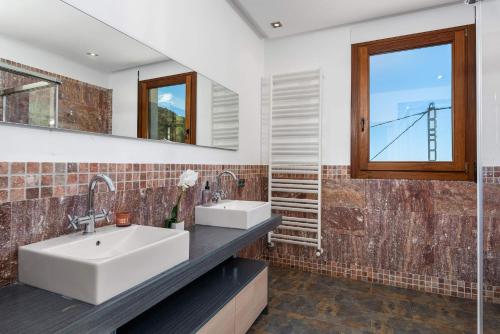 卡尔佩Villa Anis - PlusHolidays的一间带两个盥洗盆和窗户的浴室