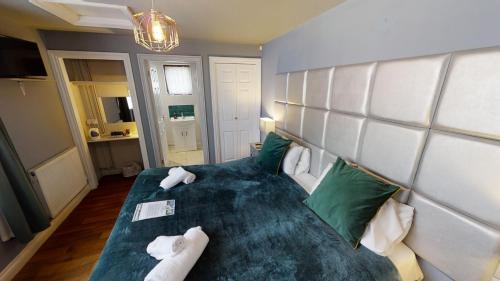 Longhope农场男孩宾馆的一间卧室配有一张带绿色和白色枕头的大床