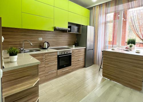 巴甫洛达尔Апартаменты в новом ЖК的厨房设有木制橱柜和绿色的墙壁