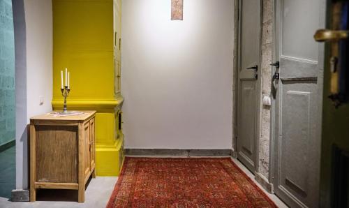 久姆里Kotun Gyumri的一条黄色墙壁的走廊和一间带地毯的房间