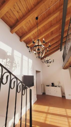 斯泰扎诺CharmeRooms Villa Moroni La Depandance的客厅设有木制天花板和吊灯。