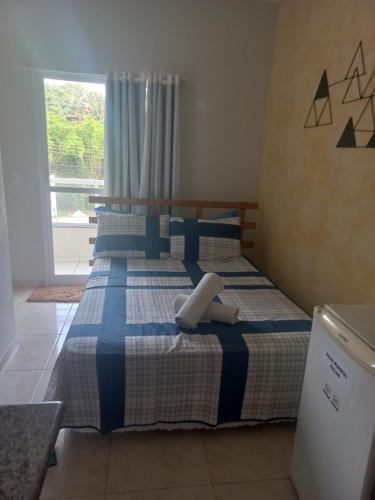 瓜拉派瑞Pousada Aloha Guarapari的一间卧室配有两张带蓝白色床单的床