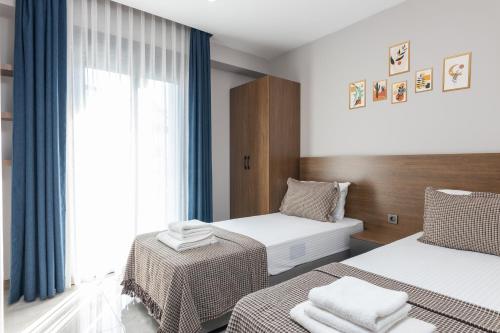安塔利亚BİSUİTES的酒店客房设有两张床和窗户。