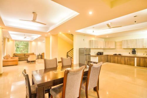 莫尔穆冈Luxury 3BHK Villa with Private Swimming Pool near Candolim的厨房以及带桌椅的用餐室。