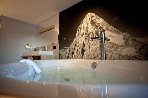格林德尔瓦尔德Eiger Mountain & Soul Resort的一间带浴缸的浴室,享有山脉美景