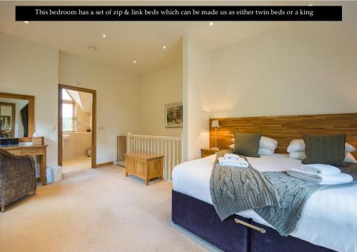 肯莫尔Mains of Taymouth Country Estate 5* Maxwell Villas的卧室配有一张大床,配有一张木制床头板,可拼成
